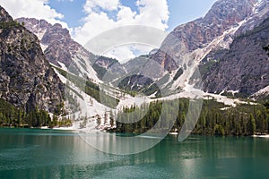 Mudflow with snow high in the Alpine mountains lake, Lago Di Braies photo