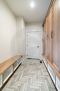Mudroom interior with white fire door and a flooring with herringbone pattern