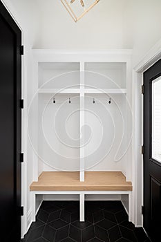 A mudroom with white organization and a wooden bench.