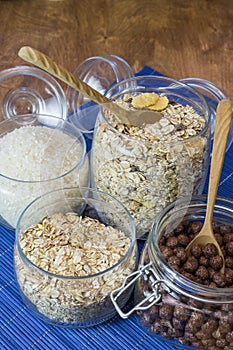 Muesli, breakfast cereal, cereal and rice in a glass container on a wooden table. Rustic food.
