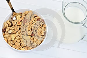 Muesli in ceramic bowl and pitcher with milk