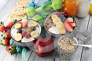 Muesli with dairy and fruit, healthy lifestyle. bowl of cereal, fruit and dumbbell.