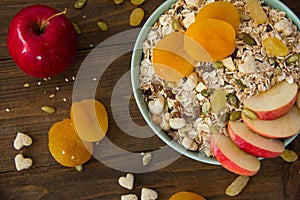 Muesli with dried apricots and apples on a table in a plate