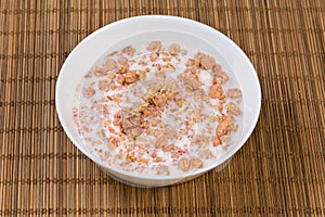 Muesli with dried fruits drenched in milk in bowl