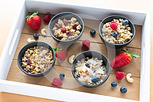 muesli with fresh fruit on a wooden tray