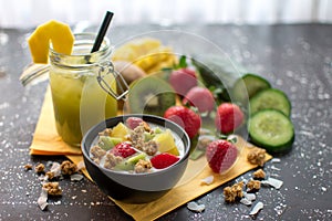 Muesli with fresh strawberries, kiwi, mango and coconut flakes