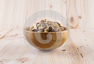 Muesli, granola and milk in blurred wooden background. (Shallow aperture intended for the aesthetic quality of the blur)