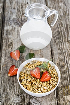 Muesli and a jug of milk for breakfast. Granola with strawberry