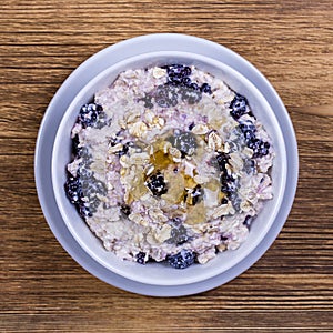 Muesli made from blackberry, oat flakes with yogurt and honey, close up