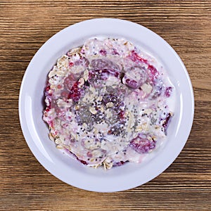 Muesli made from raspberry, oat flakes, chia seeds with yogurt and honey, close up