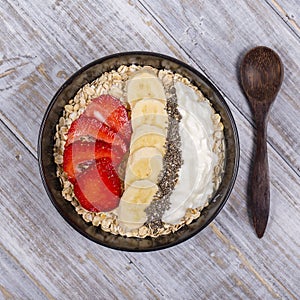 Muesli made from red strawberries, banana, chia seeds, oat flakes, honey and dressed with yogurt