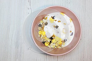 Muesli with on a pink plate, top view. Muesli with fresh milk, yogurt or kefir. Muesli is made from oatmeal, a mixture