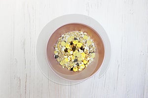 Muesli with on a pink plate, top view. Muesli with fresh milk, yogurt or kefir. Muesli is made from oatmeal, a mixture