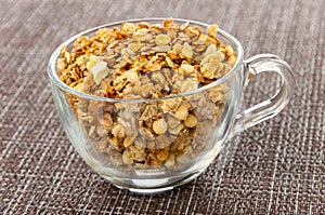 Muesli in transparent cup on mat