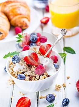 Muesli with yogurt and berries on a wooden table. Healthy fruit and cereal brakfast