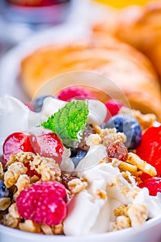 Muesli with yogurt and berries on a wooden table. Healthy fruit and cereal brakfast