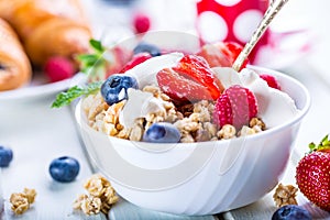 Muesli with yogurt and berries on a wooden table. Healthy fruit and cereal brakfast