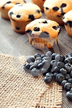 Muffin with blueberries on a wooden table.
