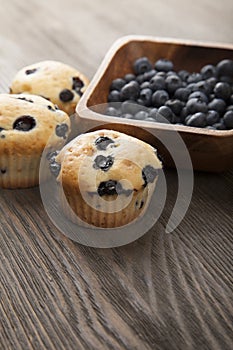 muffin with blueberries on a wooden table. fresh berries and sweet pastries on the board.