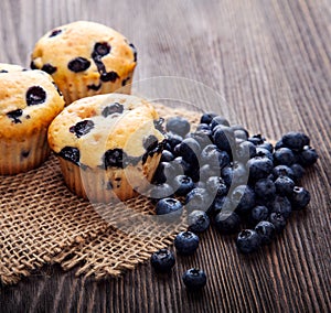 Muffin with blueberries on a wooden table. fresh berries and sweet pastries on the board