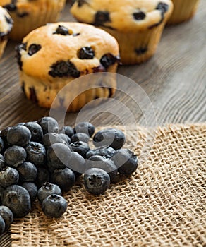 muffin with blueberries on a wooden table. fresh berries and sweet pastries on the board