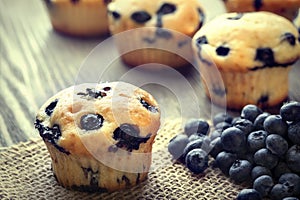 muffin with blueberries on a wooden table. fresh berries and sweet pastries on the board.