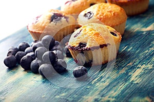 muffin with blueberries on a wooden table. fresh berries and sweet pastries on the board.