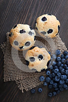 muffin with blueberries on a wooden table. fresh berries and sweet pastries on the board.