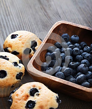 muffin with blueberries on a wooden table. fresh berries and sweet pastries on the board.