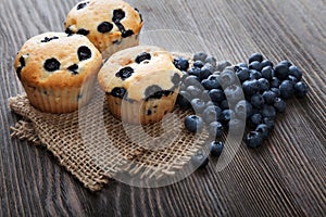 muffin with blueberries on a wooden table. fresh berries and sweet pastries on the board.