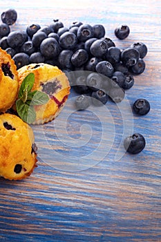 muffin with blueberries on a wooden table. fresh berries and sweet pastries on the board.