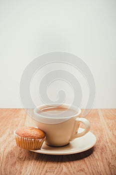 Muffin with coffee cup on wooden table. Selective focus. On a white background with copyspace. Coffee break