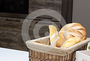 Muffin lies in the kitchen in a small basket, loaves, bread and rolls. Bad food, fullness, copy space