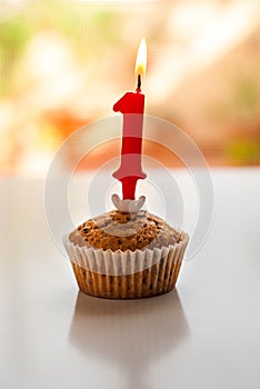 Muffin with a lit number one candle