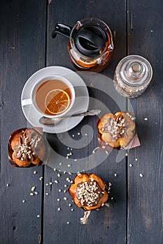 Muffin with milk chocolate and nuts, flavored orange tea on wooden background top view