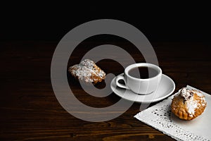 Muffin with white cup of coffee on a dark wooden background