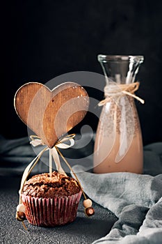 Muffin with wooden heart tag, cocoa drink