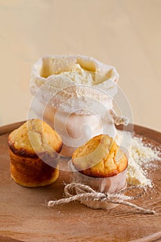 Muffins and a bag of flour on the round board