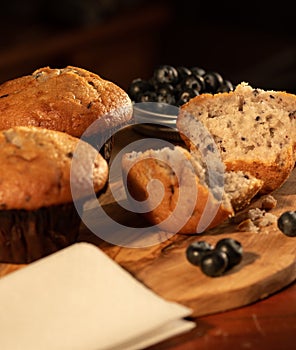 Home nade muffins with blueberries on wooden chopping board. photo