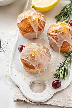 Muffins, cakes with cranberry and lemon on a white board.