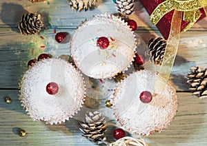 Muffins, cakes with cranberry and pecan nuts. On the background of cones and present.