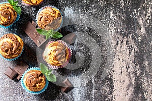 Muffins with chocolate and mint on the background of dark slate. Top view flat lay background.