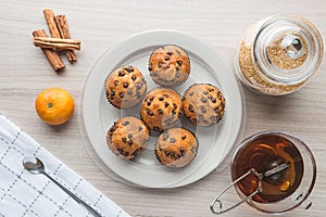 Muffins, cup of tea, sugar, tangerine and cinnamon
