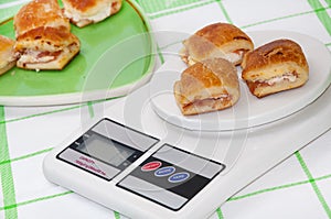 Muffins with ham and cheese on the digital kitchen scale