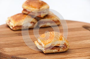 Muffins with ham and cheese on the kitchen wooden board