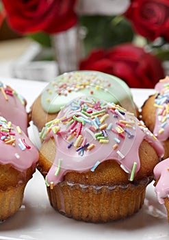 Muffins with pink icing and colorful sprinkles