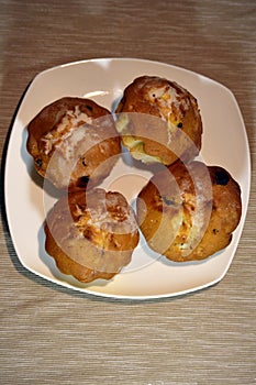 Muffins on plate with selective focus on nearest muffin.