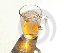 Mug of beer close-up on a white background, shadows from objects