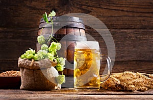 Mug of beer with green hops and wheat ears