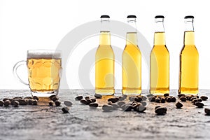 Mug with beer near bottles and coffee grains on brown textured surface.